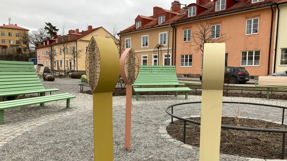 Lekpark med träbänkar. Även pelare som liknar blomknoppar, foto.