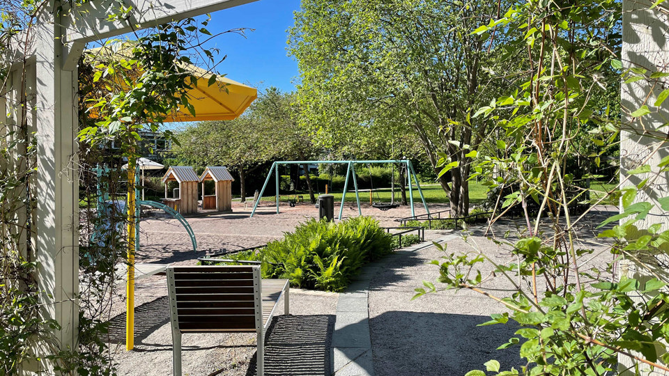 Lekplats med bland annat gungor, sittplatser, klätterställning och lekhus.