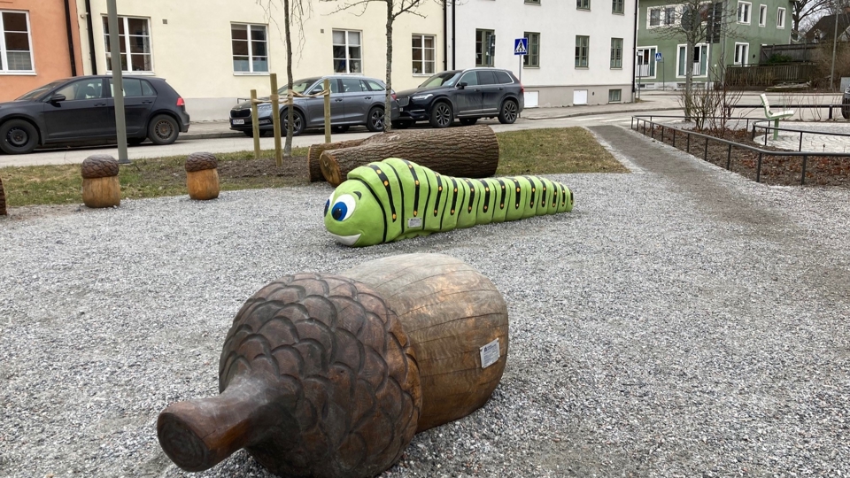 Träfigurer föreställande larv och ekollon i lekpark, foto. 