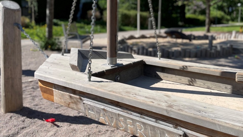 En träbåt "Havsfrun" att klättra i, som hänger i kättingar.