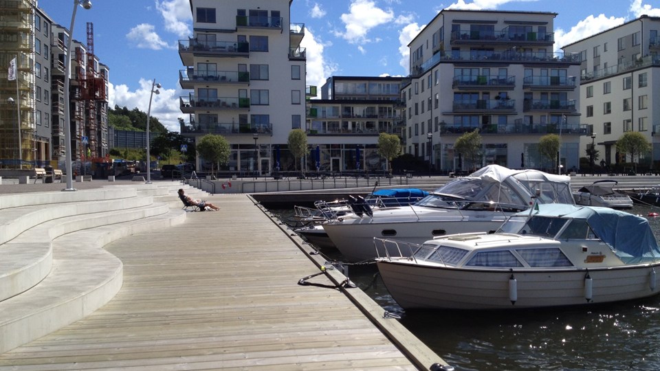 En kaj med båtplatser och ett par förtöjda båtar i Hammarby sjöstad.