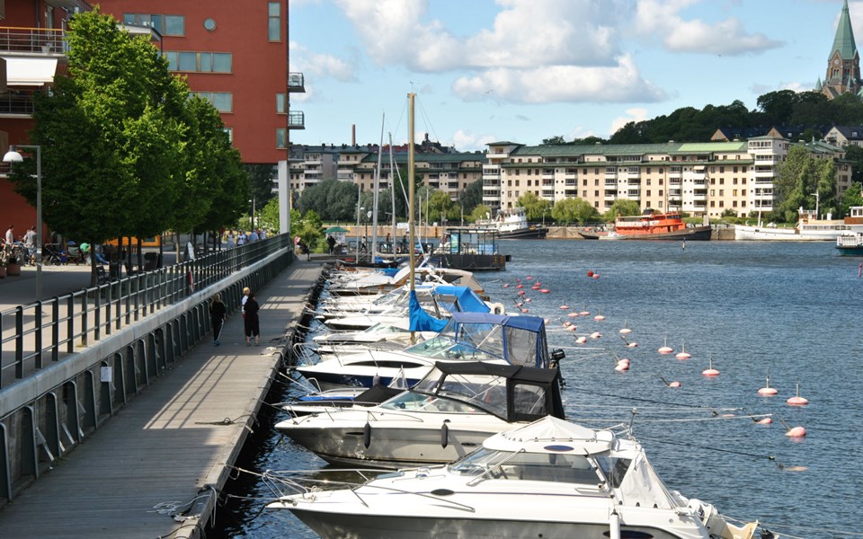 En kaj med båtplatser och en rad förtöjda båtar i Hammarby Sicklakanalen.
