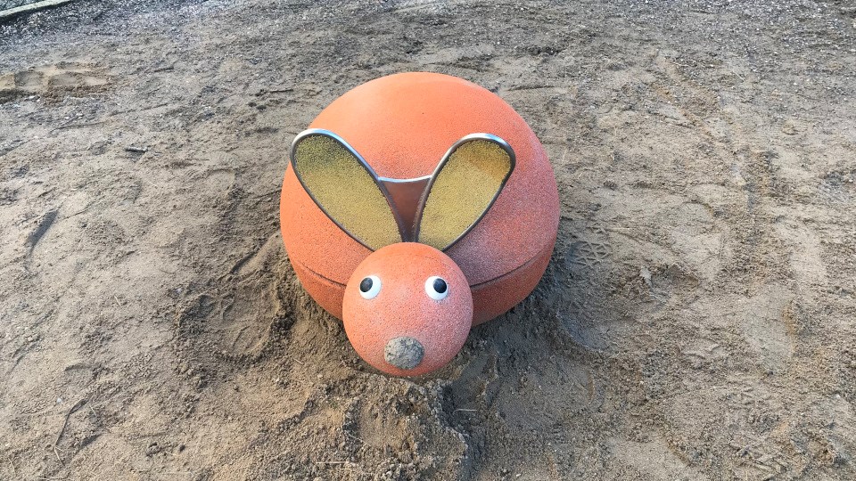 Ett lekdjur i form av en kanin som är placerad i baksand.