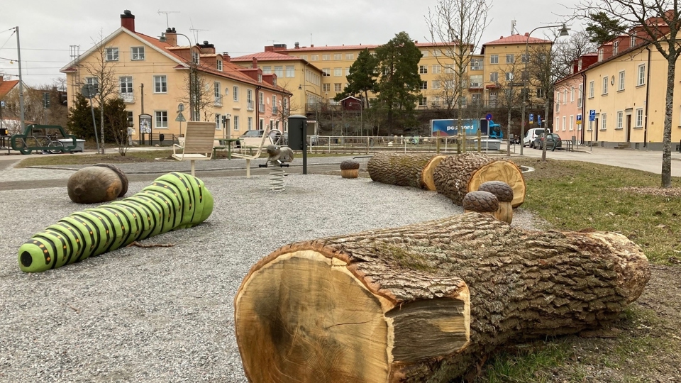 Lekplats med träfigurer i bostadsområde, foto.