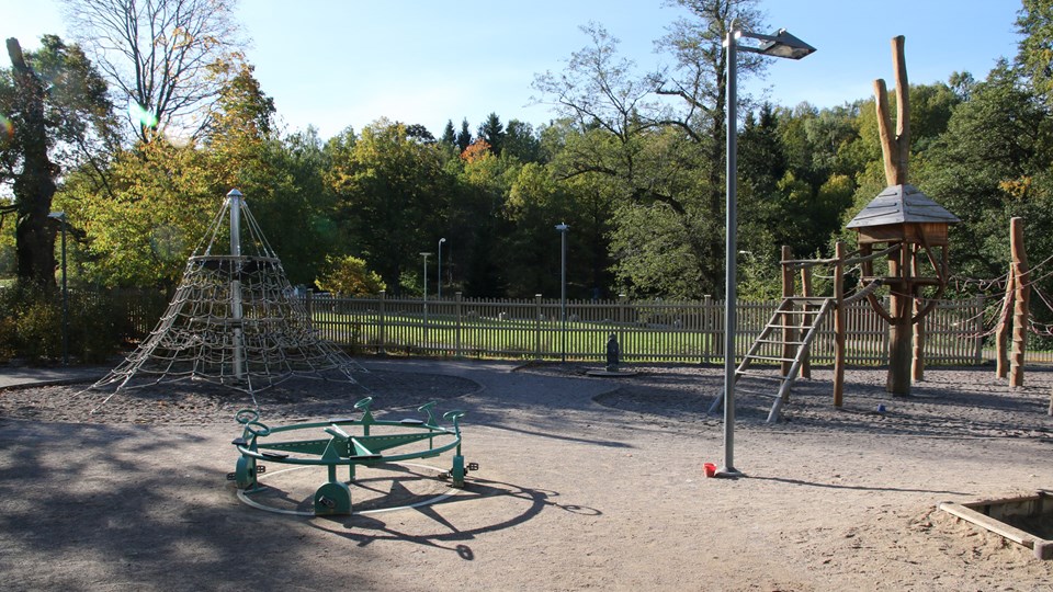 Klätterlek och cykelkarusell i naturnära lekplats.