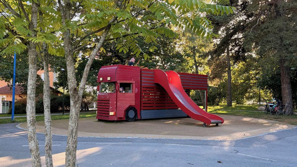 Lekpark med rutschkana i form av en röd lastbil, foto.